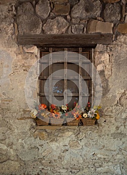 Old Stone Building with Baskets of Fall Flowers on the Wooden Window Sill