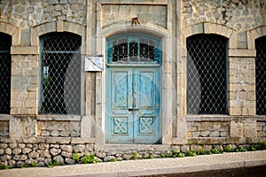 Old stone building with a blue wooden door in Karabagh