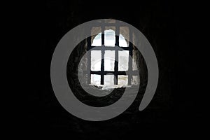 Old stone castle window with iron bars photo