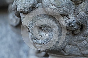 Old stone cherub head from side in Umea city