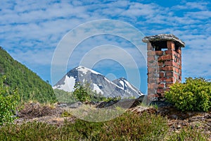 Old stone chimney on an old cottage with grass roof