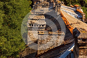 Old stone chimneys on the roof.