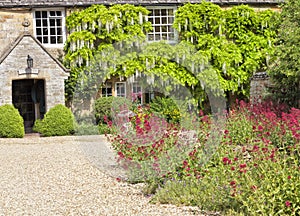 Old stone Cotswold cottage with courtyard flower garden