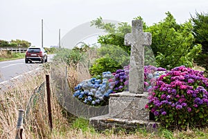 Old stone cross and car