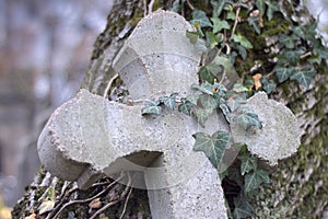 Old stone cross overgrown with ivy and moss