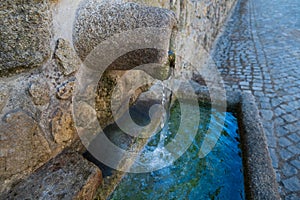 Old stone drinking water fountain in rural Portugal, close up.