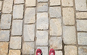 Old stone footpath and a man in red shoes