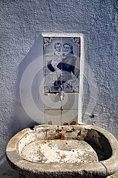 Old stone fountain with blessed water by saint