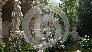 Old stone fountain in the botanical garden Trsteno, near Dubrovnik, Croatia. Statue of Neptune, goldfish in the water