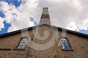 An old stone house with arched windows and a chimney. Victorian style. Vintage architecture detail