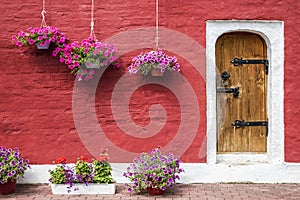 Old stone house decorated with colorful petunia flowers