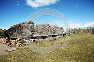 Old stone house inside Eketorps borg with straw roof