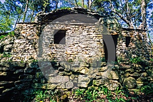 Old stone house by a rock in the forest
