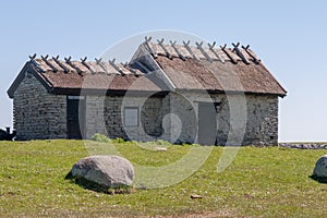 An old stone house stands on a green meadow. Oland, Sweden