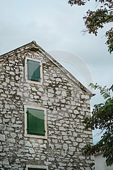 Old stone house and windows with closed shutters in Biograd na Moru of Croatia