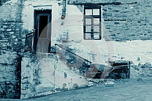 Old Stone House With Wooden Door and Window, Staircase, Rusty Gutter and Wheelbarrow i Cyan