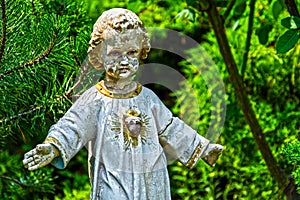 Old stone Jesus Christ in a green garden