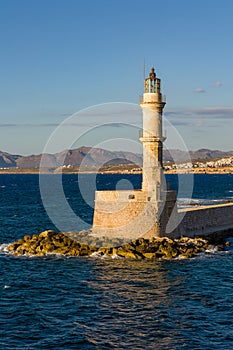 An old stone lighthouse guarding the entrance to a port Chania, Crete, Greece