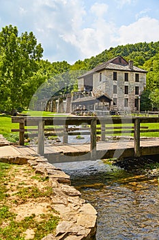 Old Stone Mill with wooden walking bridge over tiny creek