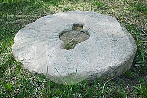 Old stone millstone in the grass