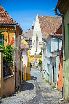 Old stone paved street with tourists from Sighisoara