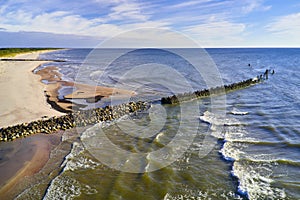 An old stone ruined pier at low tide. A landscape with a pleasant shore