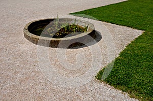 Old stone sandstone carved fountain converted into a pond with water lilies and irises. formerly a watering hole for horses. forma