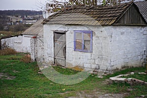 Old stone shed with cracks in the walls. Movements in masonry buildings. Deformation of walling