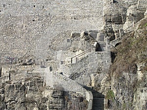 Old stone staircase near a large stone wall