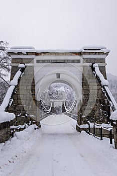 Old stone suspension bridge in Norway snow