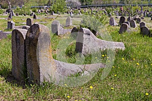 Old stone tombstones on ancient Jewish cemetery in sunny day