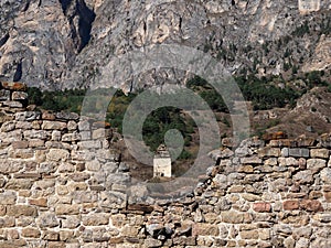 Old stone wall with arched passage. Old Pyaling towers complex, one of the largest medieval castle-type tower villages, located on