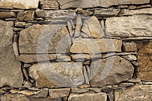 An old stone wall brown large stones. Classical masonry walls of medieval castles in Europe.