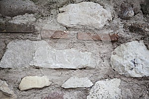 An old stone wall brown,white, black large stones. Classical masonry walls of medieval castles in Europe.