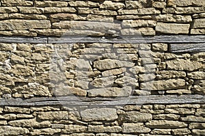 Old stone wall closeup with two beams