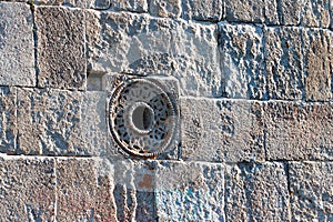 Old stone wall with decorated round hole
