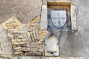 Old stone wall with niches and wooden shield stamp in Burgundy, France