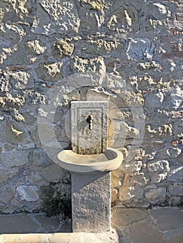 Old stone wall and stone washstand on the backyard.