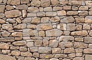 Old stone wall stones fitted together without cement