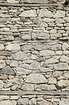 Old stone wall with three wooden beams