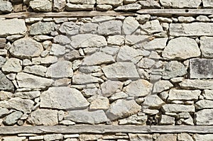 Old stone wall with two wooden beams closeup