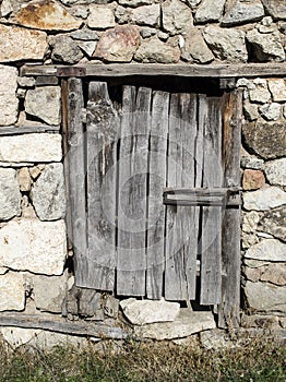 Old stone wall with wooden padlocked door