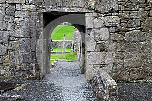 Old stone walls and archways leading to gravestones in old cemetery
