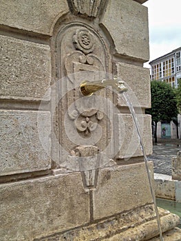 Old stone water fountain on the street in Spain