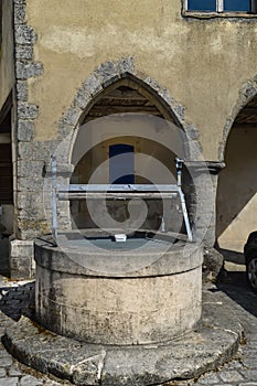 Old stone well with salamanders forging