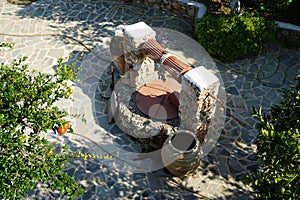 An old stone well for water with a bucket and jugs is located near the Epar. Od. Lardou-Lindou road in Lardos, Rhodes, Greece