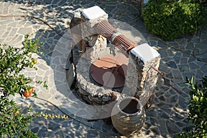 An old stone well for water with a bucket and jugs is located near the Epar. Od. Lardou-Lindou road in Lardos, Rhodes, Greece