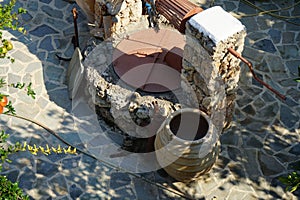 An old stone well for water with a bucket and jugs is located near the Epar. Od. Lardou-Lindou road in Lardos, Rhodes, Greece