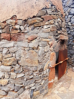 Old stone wood oven with iron door. Close up of traditional stone construction. Architecture and Constructions