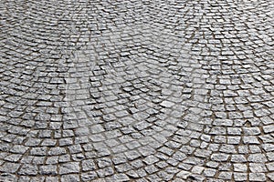 An old stoneblock pavement cobbled in an arc pattern. Photo in perspective